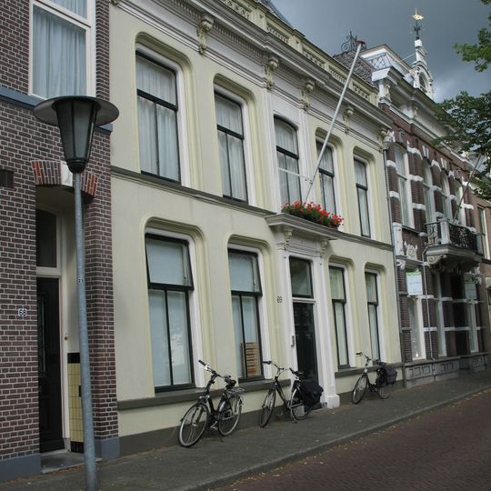 Deftig herenhuis met kroonlijst met consoles en balustrade onder dwars zadeldak tussen puntgevels