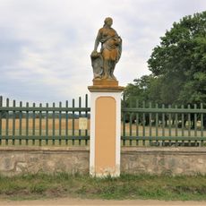 Alegorická socha Červen v ohradě zámecké zahrady ve Veltrusech