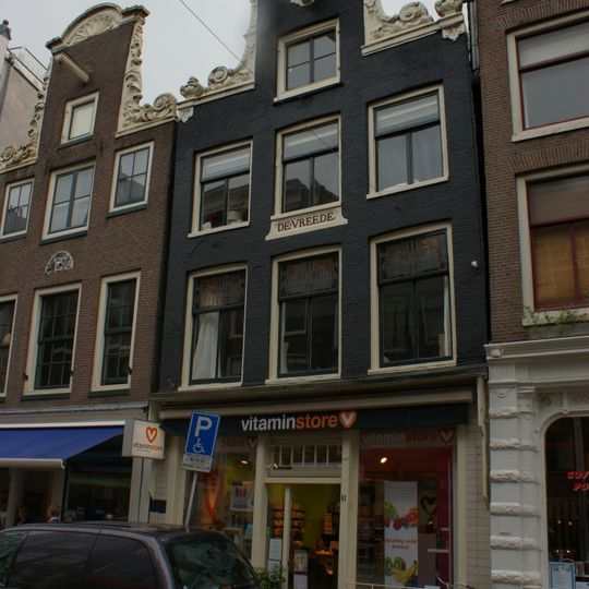 Pand met halsgevel met gedeelde vleugelstukken, hoekvazen, gelobde afdekking en incompleet ornament om de hijsbalk