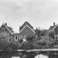 Fraai pand onder zadeldak. Houten geveltopbeschietingen, aan de voorzijde met gesneden windveren.