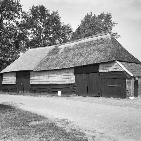 Schuurtje met wanden van stro en hout onder rieten schilddak