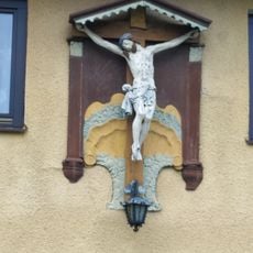 Pamětní kříž na zdi domu na křižovatce ulic Benešova a Komenského ve Sloupu v Čechách