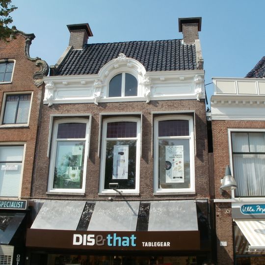 Pand onder dwarskap tussen topgevels waarboven schoorstenen