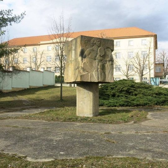 Kamenná plastika mezi domy v ulici Tomanova ve Slaném