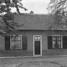 Boerenwoning, bakstenen gebouw onder afgewolfd rieten zadeldak