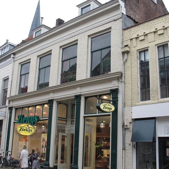 Pand met geverfde lijstgevel en winkelpui onder dwars zadeldak