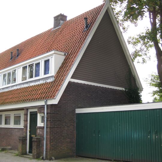 Blok met 4 keukenwoningen, zo genoemd vanwege destijds nieuwe plaatsing van keuken aan de voorzijde, aan de zijkant een houten topgevel, bouwstijl Amsterdamse School.