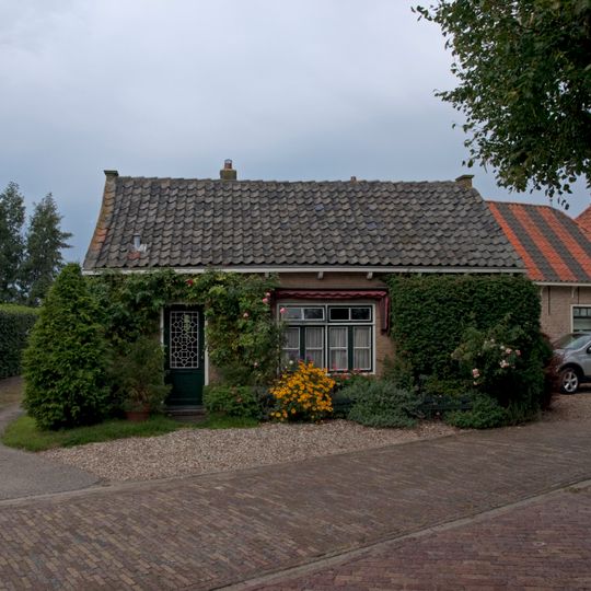 Hoeve op L-vormige plattegrond onder pannen daken. Daklijst met consoles