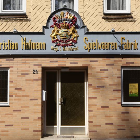 Geschnitzter Wappenschild der Spielwarenfabrik