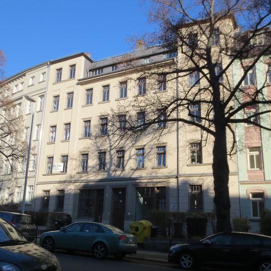 Mietshaus in geschlossener Bebauung mit Vorgarten sowie Kleinpflaster vor den Läden des Hauses Zeißstraße 4