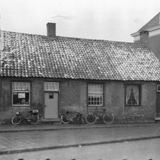 Pand zonder verdieping, onder pannen zadeldak, dat doorloopt over nr 12