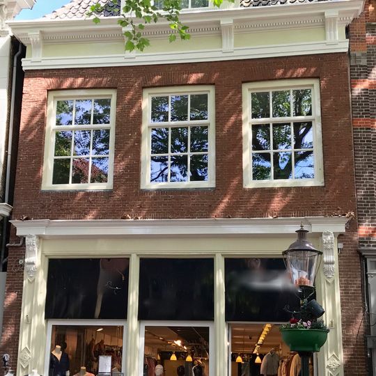 Pand onder zadeldak met in voorgevel gootlijst met consoles en topgevel aan de achterzijde