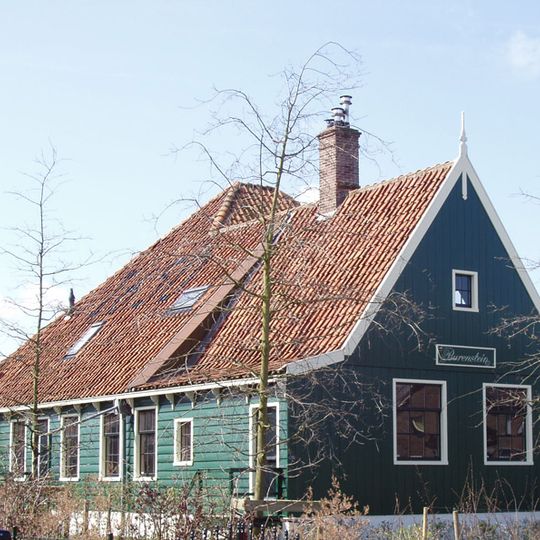 Houten boerderij, achter het woonhuis een vierkante stal met hoog dak