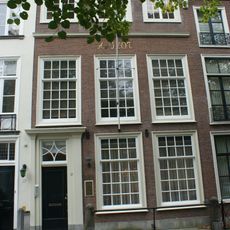 Pand met in latere tijd verhoogde gevel met versierde deurpartij