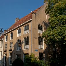 Pand met gepleisterde verminkte topgevel