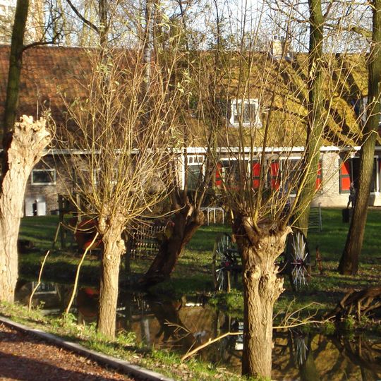 Boerderij, bestaande uit een parallel aan de dijk gebouwd woonhuis, onder een zadeldak met de daarnaast gelegen stal. In het woonhuis vensters met luiken en 12-ruitsschuiframen