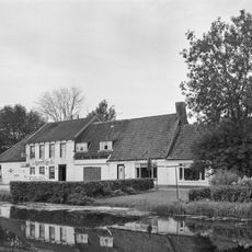 Cafe. Pand met geverfde gevel, gedekt door dwarse zadeldaken; het middelste gedeelte voorzien van een verdieping