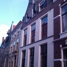 Onderkelderd huis met door natuursteen gedekte klokgevel voorzien van aanzetvoluten