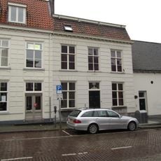 Huis met gebosseerd gepleisterde lijstgevel